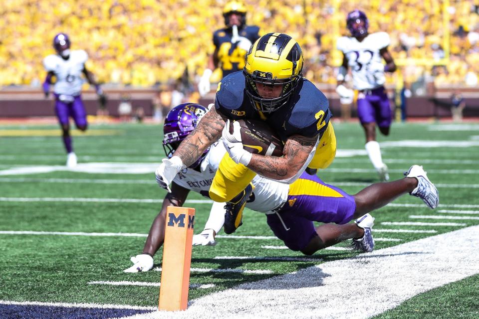 Michigan running back Blake Corum (2) dives for a first down against East Carolina defensive back Isaiah Brown-Murray (26) during the first half at Michigan Stadium in Ann Arbor on Saturday, Sept. 2, 2023.