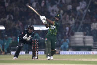 Pakistan's Fakhar Zaman, center, plays a shot as New Zealand's Tom Blundell watches during the fourth T20 international cricket match between Pakistan and New Zealand, in Lahore, Pakistan, Thursday, April 25, 2024. (AP Photo/K.M. Chaudary)