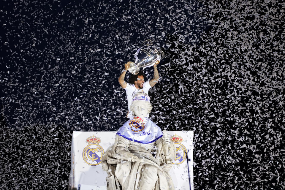 FILE - Real Madrid player Marcelo holds the trophy at Cibeles Square in front of the City Hall in Madrid, Spain, May 29, 2022. A group of top soccer clubs face Champions League organizer UEFA in court on Monday, July 11, 2022, for a legal match that risks the biggest upheaval in European soccer for more than 25 years. The Super League project failed at launch 15 months ago but the company formed by the 12 rebel clubs — now led by Real Madrid, Barcelona and Juventus — has brought a case to the Court of Justice of the European Union in Luxembourg. (AP Photo/Andrea Comas, File)