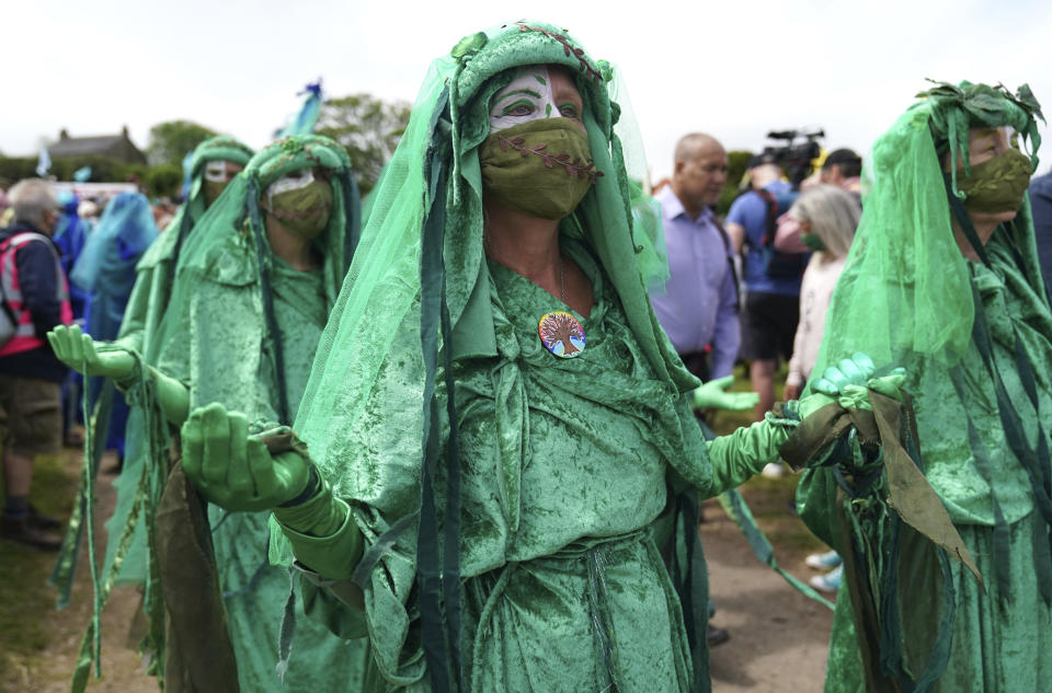 Climate activists are dressed in costumes as they demonstrate near the G7 meeting taking place in St. Ives, Cornwall, England, Friday, June 11, 2021. Leaders of the G7 begin their first of three days of meetings on Friday in Carbis Bay, in which they will discuss COVID-19, climate, foreign policy and the economy. (AP Photo/Jon Super)