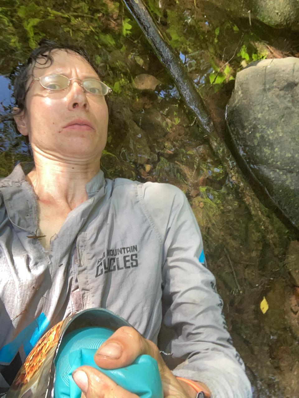 Andrea Larson lies in a shallow stream while attempting a speed record on the Superior Hiking Trail. The heat was her biggest obstacle, so she would cool off when she could.