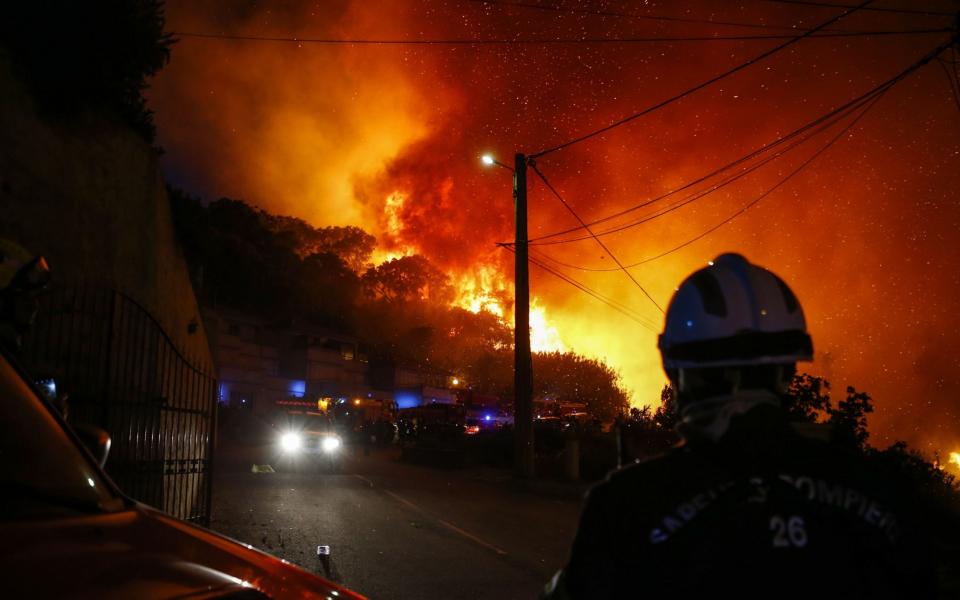 Firefighters work to put out a fire in Biguglia, on the French Mediterranean island of Corsica, on July 24, 2017 - AFP