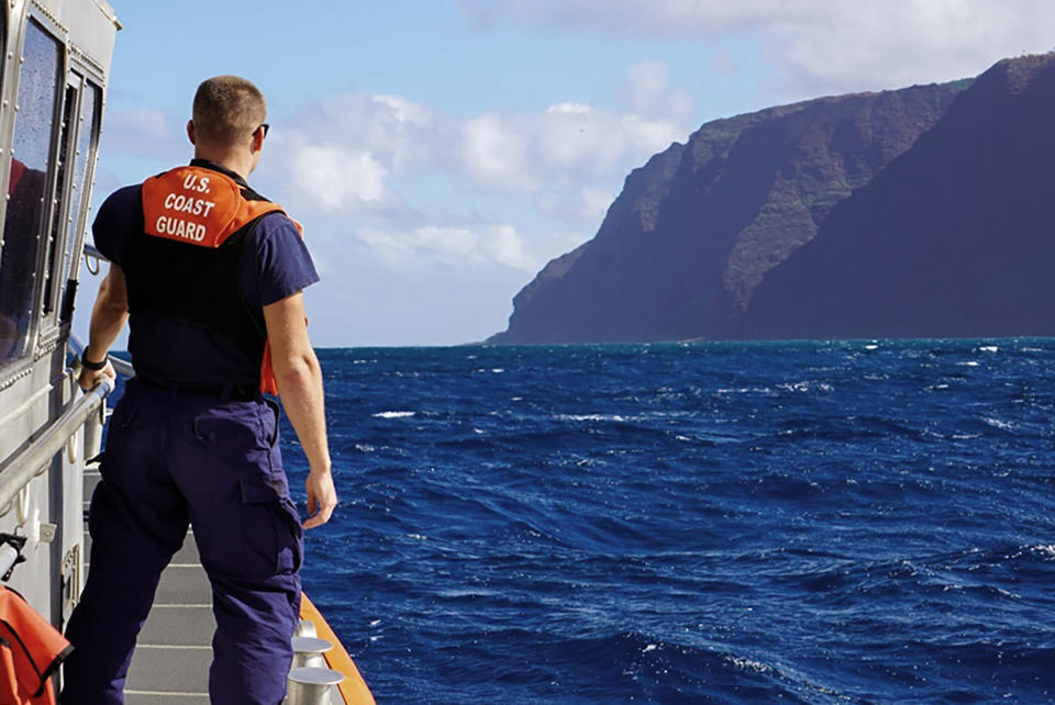 CORRECTS THE NAME OF THE PHOTOGRAPHER - In this photo released by the U.S. Coast Guard, Coast Guard Cutter William Hart moves toward the Na Pali Coast on the Hawaiian island of Kauai on Friday, Dec. 27, 2019, the day after a tour helicopter disappeared with seven people aboard. Authorities say wreckage of the helicopter has been found in a mountainous area on the island. (MK3 Forest Herring/U.S. Coast Guard via AP)