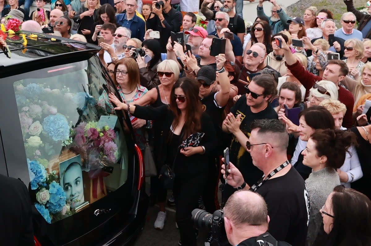 Fans of O'Connor line the streets as her funeral cortege passes through her former hometown of Bray, Co Wicklow in August (PA)
