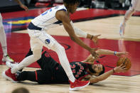 Toronto Raptors guard Fred VanVleet (23) loses the ball as he falls to the floor in front of Dallas Mavericks forward Wes Iwundu (25) during the second half of an NBA basketball game Monday, Jan. 18, 2021, in Tampa, Fla. (AP Photo/Chris O'Meara)