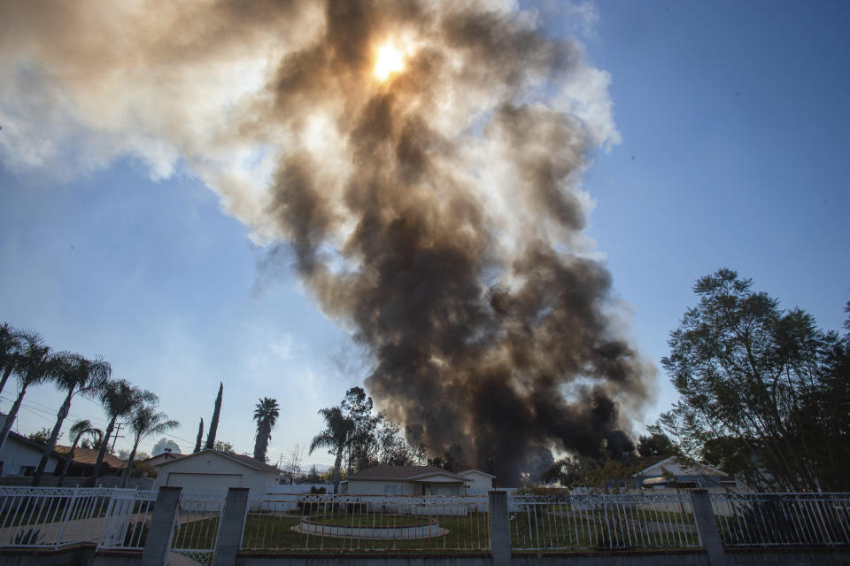 Smoke rises in the background after a fireworks stash exploded in Ontario, Calif., Tuesday, March 16, 2021. (Watchara Phomicinda/The Orange County Register via AP)