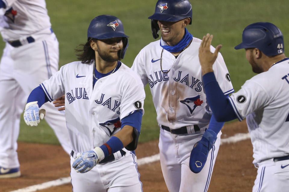 Toronto Blue Jays Bo Bichette celebrates his three-run homer with teammates against Tampa Bay Rays pitcher Aaron Loup during the sixth inning of a baseball game, Friday, Aug. 14, 2020, in Buffalo, N.Y. (AP Photo/Jeffrey T. Barnes)