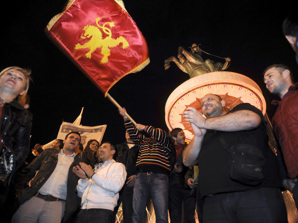 Supporters of the ruling conservative VMRO-DPMNE wave party flags in celebration of the party's double victory in parliamentary and presidential elections, in downtown Skopje, Macedonia, early Monday, April 28, 2014. Macedonia's incumbent prime minister claimed a landslide victory late Sunday in parliamentary and presidential elections, but the center-left opposition denounced what it called distorting interference in the democratic process by the ruling party and said it won't recognize the results. (AP Photo/Boris Grdanoski)