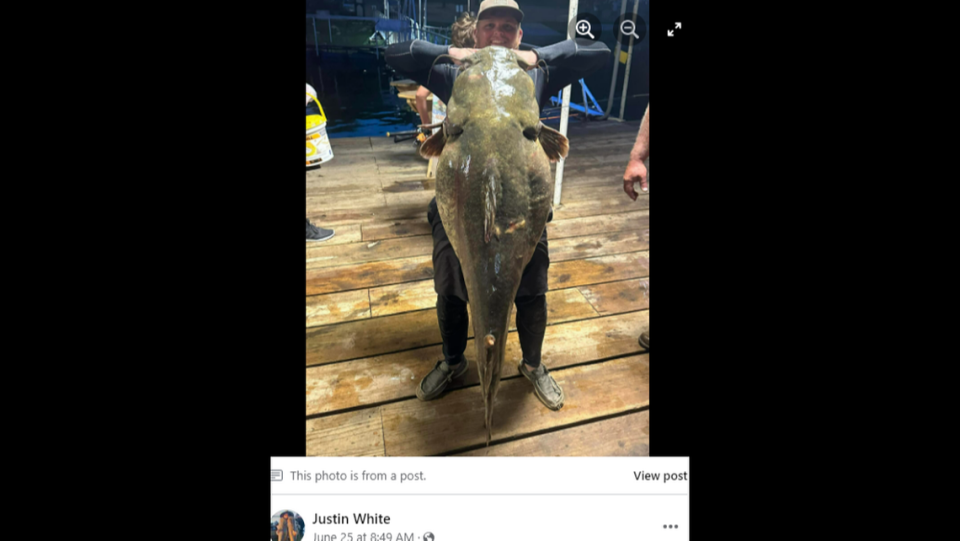 Drew Moore poses with the nearly 100-pound catfish.