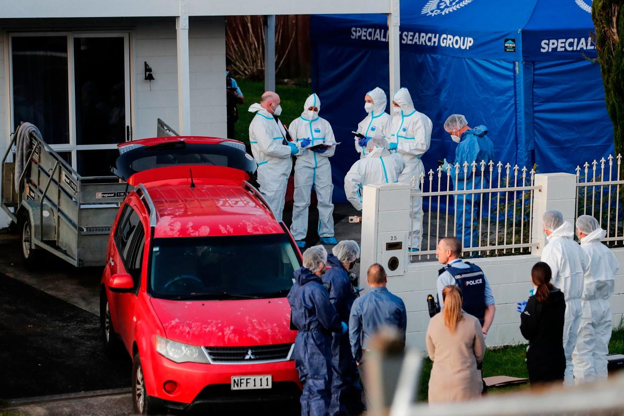 New Zealand police investigators work at a scene in Auckland on Aug. 11, 2022, after bodies were discovered in suitcases. 