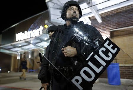 Police officers in riot gear are seen outside a Walmart store during a protest in St. Louis, Missouri, October 13, 2014. REUTERS/Jim Young