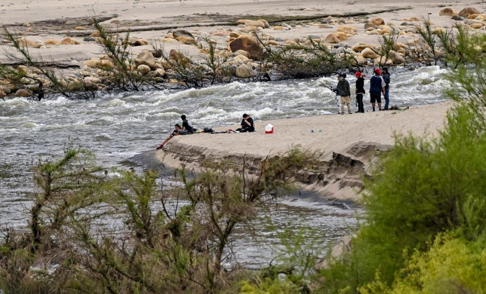 White water of the Kaweah River passes a group recreating Monday, May 1, 2023 near Slick Rock Recreation Area above Lake Kaweah. A search continues for a man last seen Friday when another man and a child were rescued from the river.