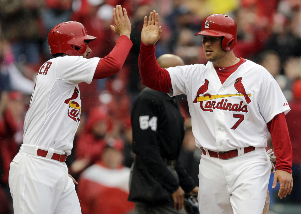 St. Louis Cardinals' Matt Holliday, right, is congratulated by teammate Matt Carpenter after scoring on a three-run double by Yadier Molina during the first inning of a baseball game against the Cincinnati Reds, Monday, April 7, 2014, in St. Louis. (AP Photo/Jeff Roberson)