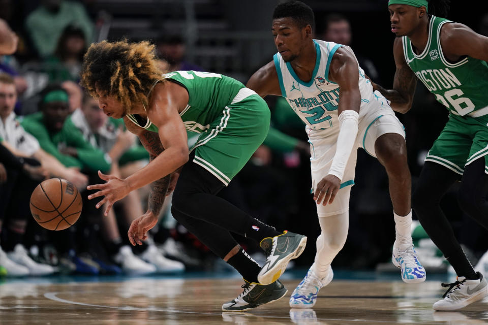 Boston Celtics guard JD Davison, left, and Charlotte Hornets forward Brandon Miller, center, battle for the ball in the second half of an NBA basketball preseason game, Thursday, Oct. 19, 2023, in Charlotte, N.C. (AP Photo/Erik Verduzco)