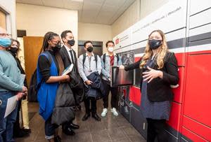 Molly Hansen, senior special programs coordinator for Bunker Hill Community College, demonstrates using a Parcel Pending by Quadient parcel locker.