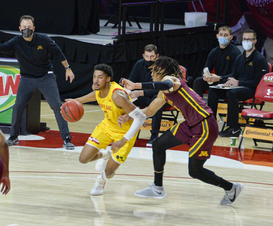 Maryland guard Aaron Wiggins, left, drives the floor against Minnesota during the first half of an NCAA college basketball game, Sunday, Feb. 14, 2021, in College Park, Md. (Kevin Richardson/The Baltimore Sun via AP)