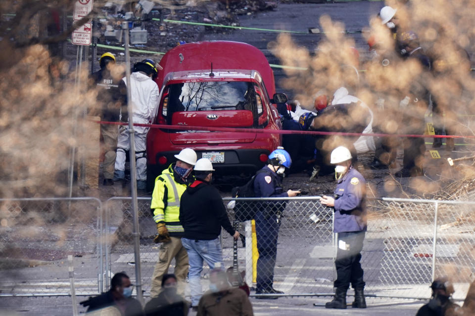 A car is inspected at the site of a Christmas Day explosion Tuesday, Dec. 29, 2020, in Nashville, Tenn. Officials have named 63-year-old Anthony Quinn Warner as the man behind the bombing in which he was killed, but his motive remains elusive. (AP Photo/Mark Humphrey)