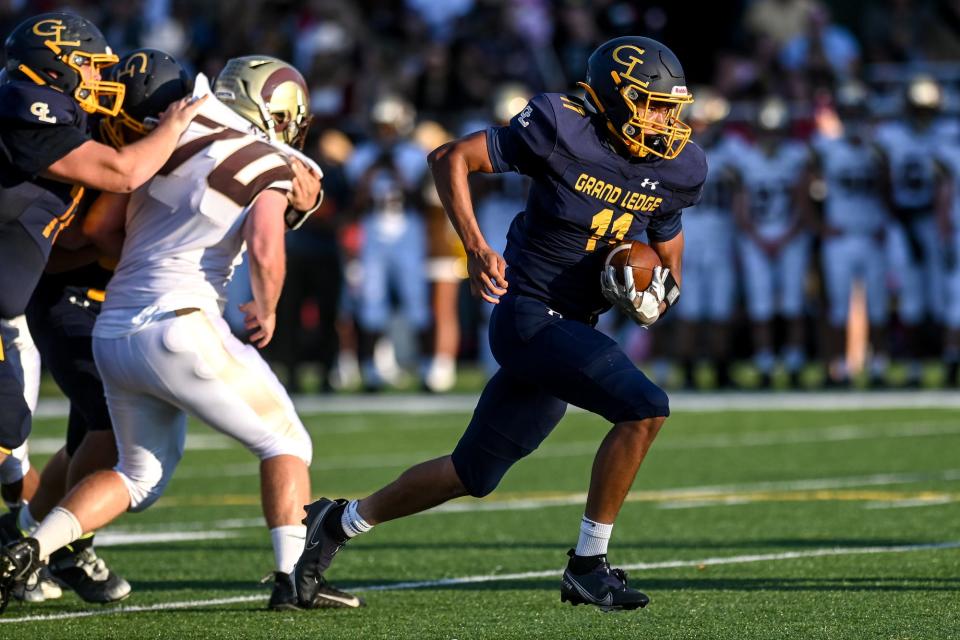 Grand Ledge's Macintyre Fourman, right, runs for a gain against Holt during the first quarter on Friday, Sept. 9, 2022, at Grand Ledge High School.