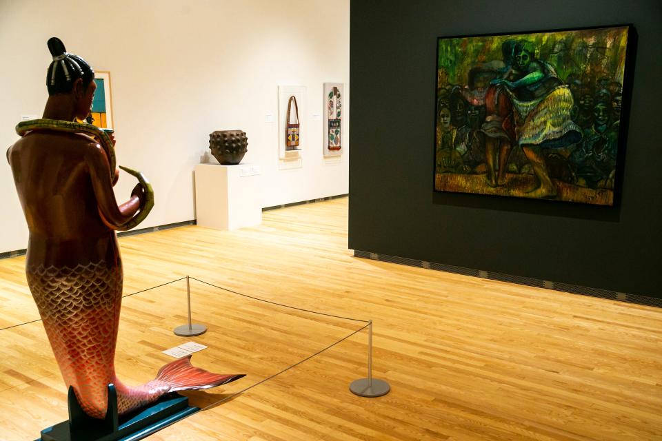 "Allegory of Time III," an oil painting on canvas by Okechukwu Emmanuel Odita, right, is seen alongside "Mami Wata" coffin by Eric Adjetey Anang, made of a northern white pine, metal fabric and acrylic paint, at left, at the Stanley Museum of Art.