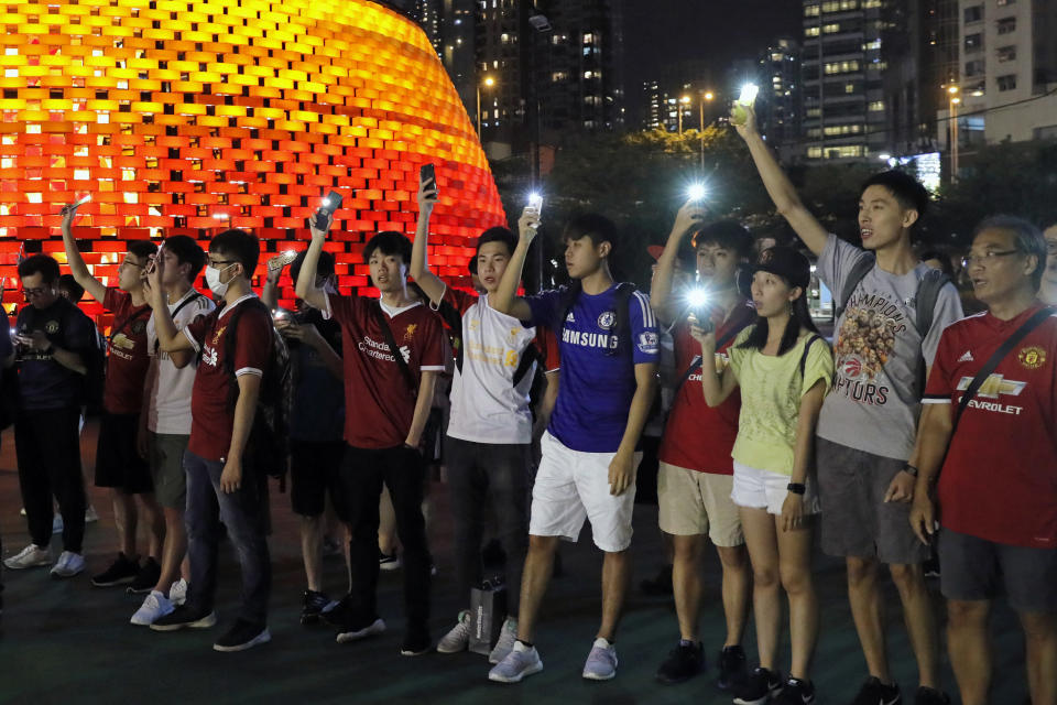 Pro-democracy football fans gather to form a human chain as they sing songs at Victoria Park in Hong Kong, Wednesday, Sept. 18, 2019. An annual fireworks display in Hong Kong marking China's National Day on Oct. 1 was called off Wednesday as pro-democracy protests show no sign of ending. (AP Photo/Kin Cheung)