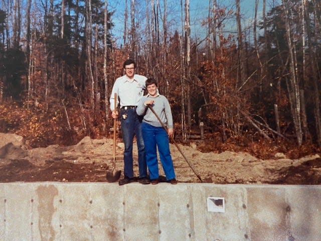 Peter and Janet Clark stand next to a concrete foundation being built for the water slide pool in the spring of 1985.