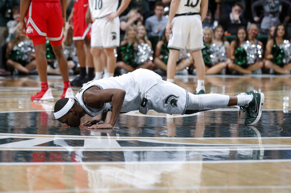 Michigan State's Cassius Winston kisses the court as he comes out late of an NCAA college basketball game against Ohio State in the second half Sunday, March 8, 2020, in East Lansing, Mich. (AP Photo/Al Goldis)