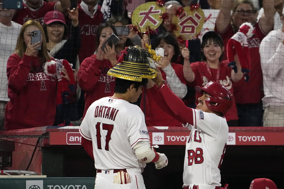 Los Angeles Angels' Shohei Ohtani, left, is presented with a Kabuto after hitting a two-run home run during the third inning of a baseball game against the Seattle Mariners Saturday, June 10, 2023, in Anaheim, Calif. (AP Photo/Mark J. Terrill)