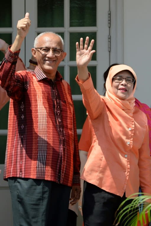 Former parliamentary speaker Halimah Yacob (R), who was named the country's new president, waves to supporters with her husband Mohammed Abdullah Alhabshee as they arrive at the nomination centre in Singapore on September 13, 2017