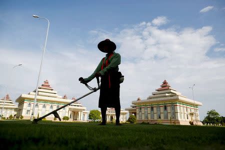 A worker cuts grass at the Parliament in Naypyitaw August 31, 2015. REUTERS/Soe Zeya Tun