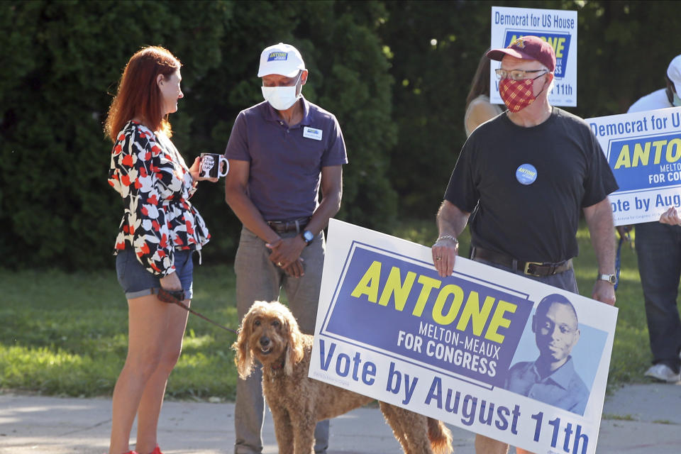 Fifth Congressional District Democrat candidate Antone Melton-Meaux, middle, visits with a resident in south Minneapolis, Tuesday, Aug. 11, 2020, primary Election Day in Minnesota. (AP Photo/Jim Mone)