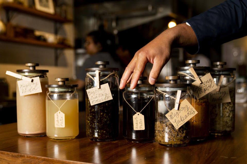 Chef Aaron Verzosa arranges the restaurant's fermented and picked products like bagoong and burong, Wednesday, May 24, 2023, in Seattle. Verzosa is nominated for a 2023 James Beard Award in the Best Chef: Northwest and Pacific category. (AP Photo/Lindsey Wasson)