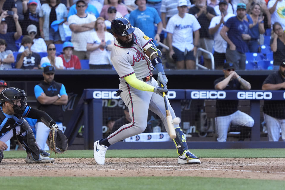 Atlanta Braves' Marcell Ozuna hits a home run scoring Ronald Acuña Jr. and Matt Olson during the ninth inning of a baseball game against the Miami Marlins, Sunday, April 14, 2024, in Miami. (AP Photo/Wilfredo Lee)
