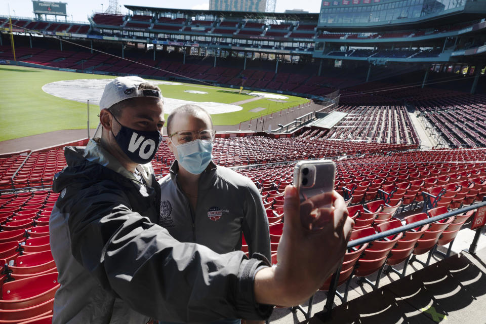 Derek Martin, left, and Casey Bishop take a selfie after voting at Fenway Park, Saturday, Oct. 17, 2020, in Boston. (AP Photo/Michael Dwyer)