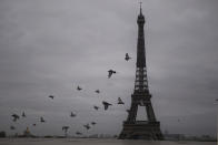 Pigeons fly next to the Eiffel Tower in Paris, Friday, Oct. 30, 2020. France re-imposed a monthlong nationwide lockdown Friday aimed at slowing the spread of the virus, closing all non-essential business and forbidding people from going beyond one kilometer from their homes except to go to school or a few other essential reasons. (AP Photo/Thibault Camus)