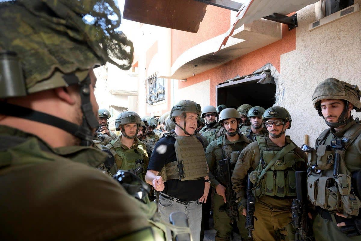 Israel’s prime minister Benjamin Netanyahu, centre, speaks to  soldiers in the Gaza Strip  (Avi Ohayon/GPO/Handout via AP)
