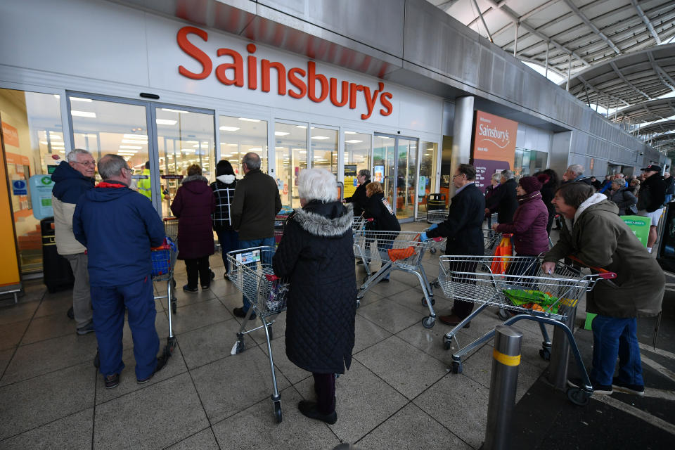 PLYMOUTH, UNITED KINGDOM - MARCH 19:  Shoppers queue outside a Sainsbury's supermarket prior to opening in Plymouth on March 19, 2020 in Plymouth, United Kingdom. The store allowed only the elderly and vulnerable into the store for the first hour. After spates of "panic buying" cleared supermarket shelves of items like toilet paper and cleaning products, stores across the UK have introduced limits on purchases during the COVID-19 pandemic. Some have also created special time slots for the elderly and other shoppers vulnerable to the new coronavirus. (Photo by Dan Mullan/Getty Images)