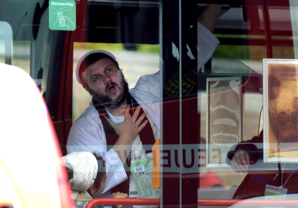 A man, wearing traditional Jewish clothing, reacts after he was escorted by the police to a bus at a Jewish cemetery and synagogue in Halle, Germany, Wednesday, Oct. 9, 2019. A heavily armed assailant tried to force his way into a synagogue Wednesday in eastern Germany on Yom Kippur, Judaism's holiest day, and two people were killed as he fired shots outside the building and into a kebab shop, authorities and witnesses said. (AP Photo Jens Meyer)