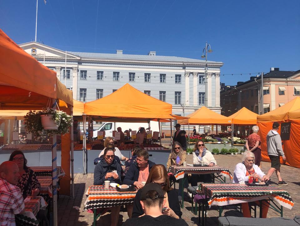 People say outside at a market stall in Helsinki