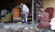 <p>Juan Moz, of Marshalltown, Iowa, helps clean out a tornado-damaged business on Main Street, Thursday, July 19, 2018, in Marshalltown, Iowa. Several buildings were damaged by a tornado in the main business district in town including the historic courthouse. (Photo: Charlie Neibergall/AP) </p>