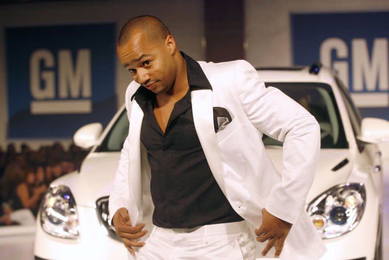 Donald Faison, dressed in Dolce & Gabbana, walks the runway with a 2007 Buick Enclave at the GM TEN fashion event in Los Angeles. Photo courtesy of General Motors