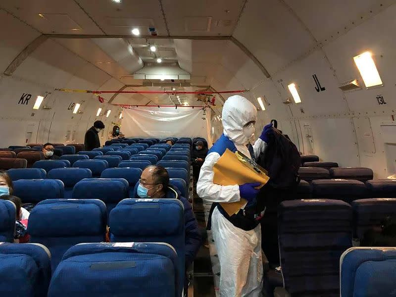 Staff from the U.S. embassy board a cargo plane in Wuhan