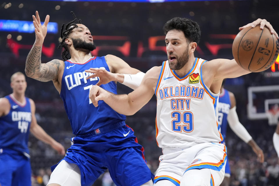 Oklahoma City Thunder guard Vasilije Micic, right, drives by Los Angeles Clippers guard Amir Coffey during the first half of an NBA basketball game Tuesday, Jan. 16, 2024, in Los Angeles. (AP Photo/Mark J. Terrill)