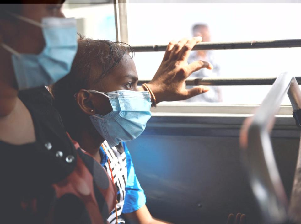 Sudhagaran Sadurshana, 9, who has acute myeloid leukaemia, rides a bus home with her mother Sudhagaran Punawadee, after being discharged from Apeksha Hospital (Reuters)