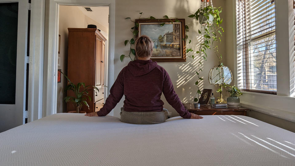 Member of testing panel sat on PurpleFlex mattress