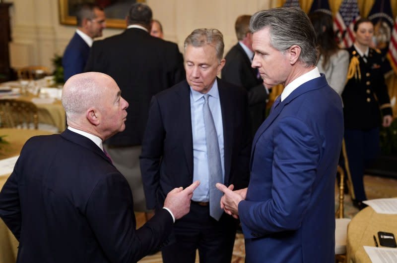 Secretary of Homeland Security Alejandro Mayorkas (L) talks with California Gov. Gavin Newson (R) during the National Governors Association Winter Meeting in the East Room of the White House on Friday. Photo by Leigh Vogel/UPI