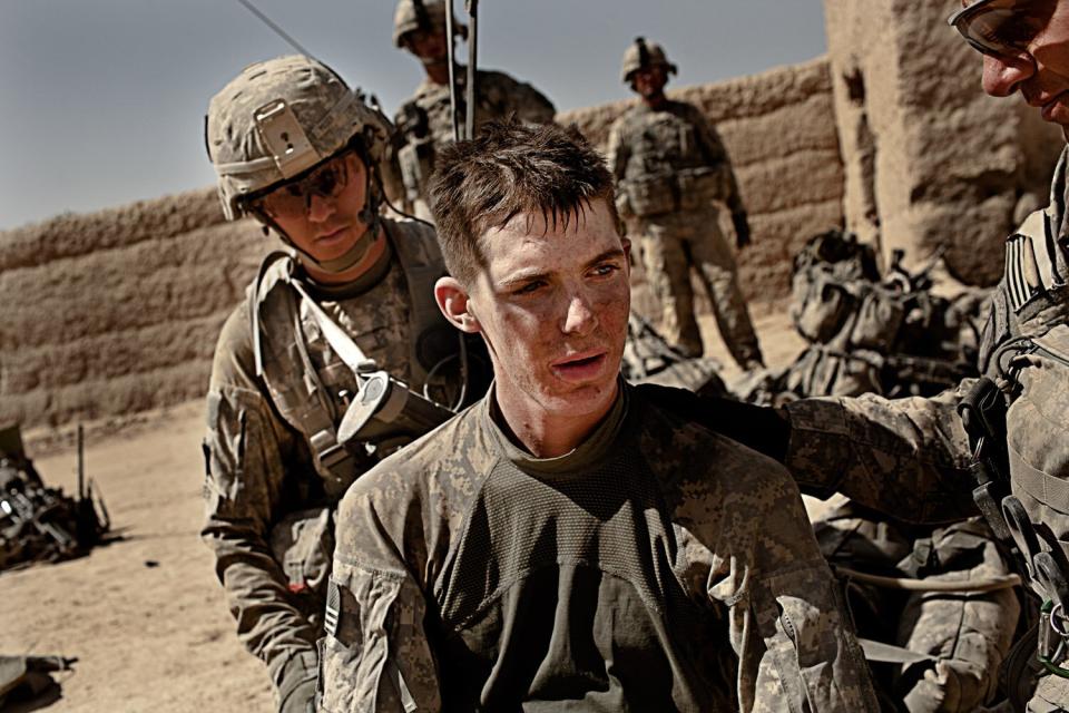 Private First Class Matthew Sharpe, 19, receives medical treatment from fellow soldiers after two IED attacks in Kandahar Province, Afghanistan. Oct. 9, 2010.