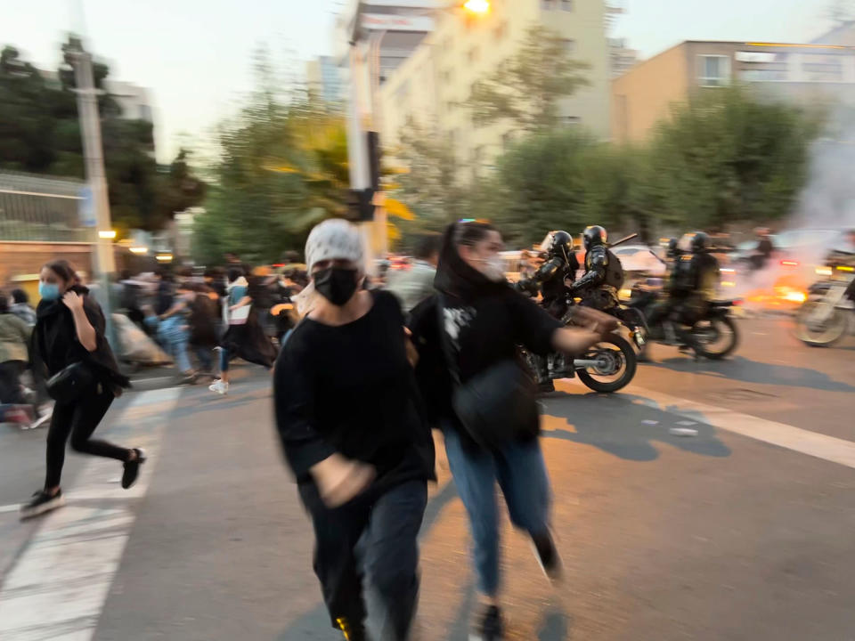 Women run away from anti-riot police during a protest of the death of a young woman, Mahsa Amini, who had been detained for violating the country's conservative dress code, in downtown Tehran, Iran, on Sept. 19.<span class="copyright">AP</span>