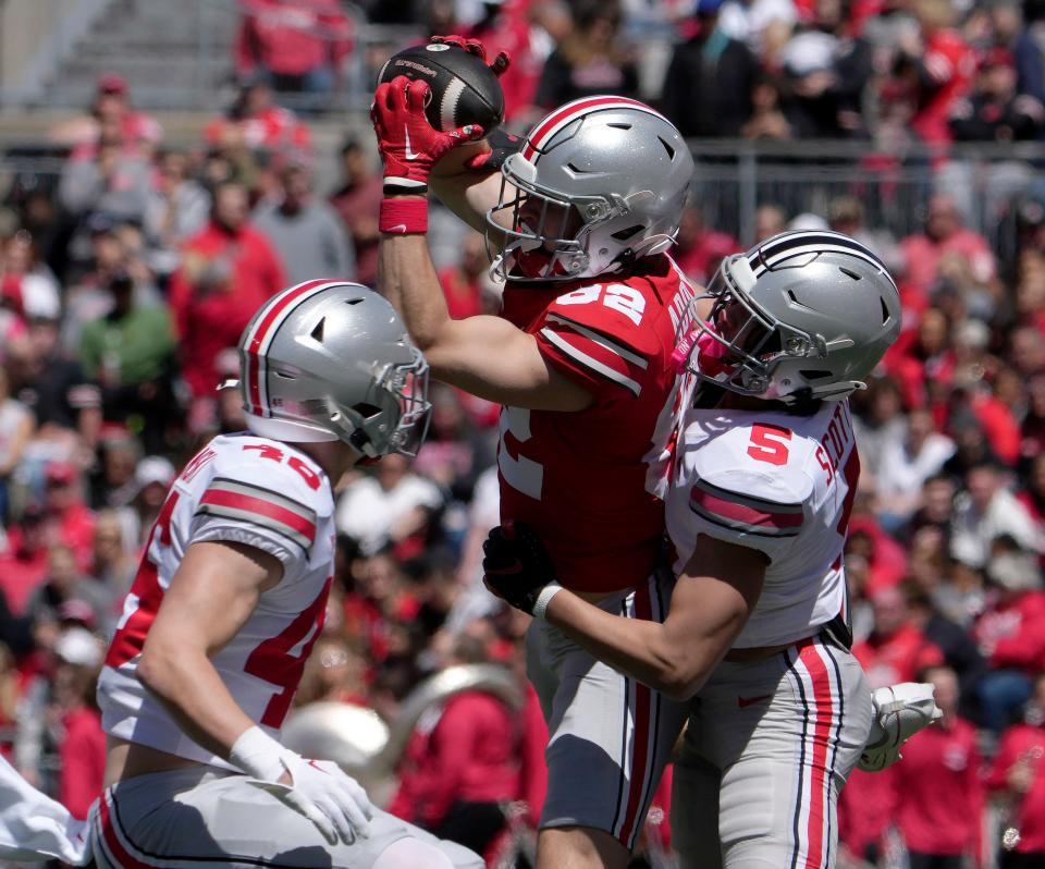 April 13, 2024; Columbus, Ohio, USA; 
Ohio State Buckeyes wide receiver David Adolph (82) is defended by safety Ryan Rudzinski (46) and defensive end Aaron Scott Jr. (5) of the grey team during the first half of the LifeSports spring football game at Ohio Stadium on Saturday.