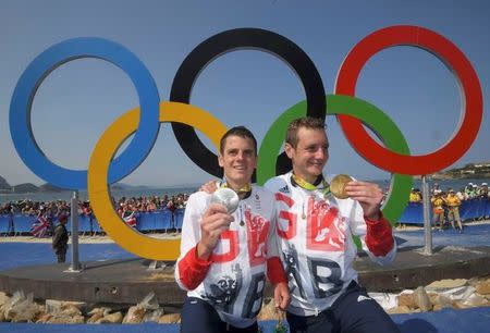 2016 Rio Olympics - Triathlon - Men's Victory Ceremony - Fort Copacabana - Rio de Janeiro, Brazil - 18/08/2016. Alistair Brownlee (GBR) of Britain and Jonathan Brownlee (GBR) of Britain pose with their gold and silver medals. REUTERS/Toby Melville