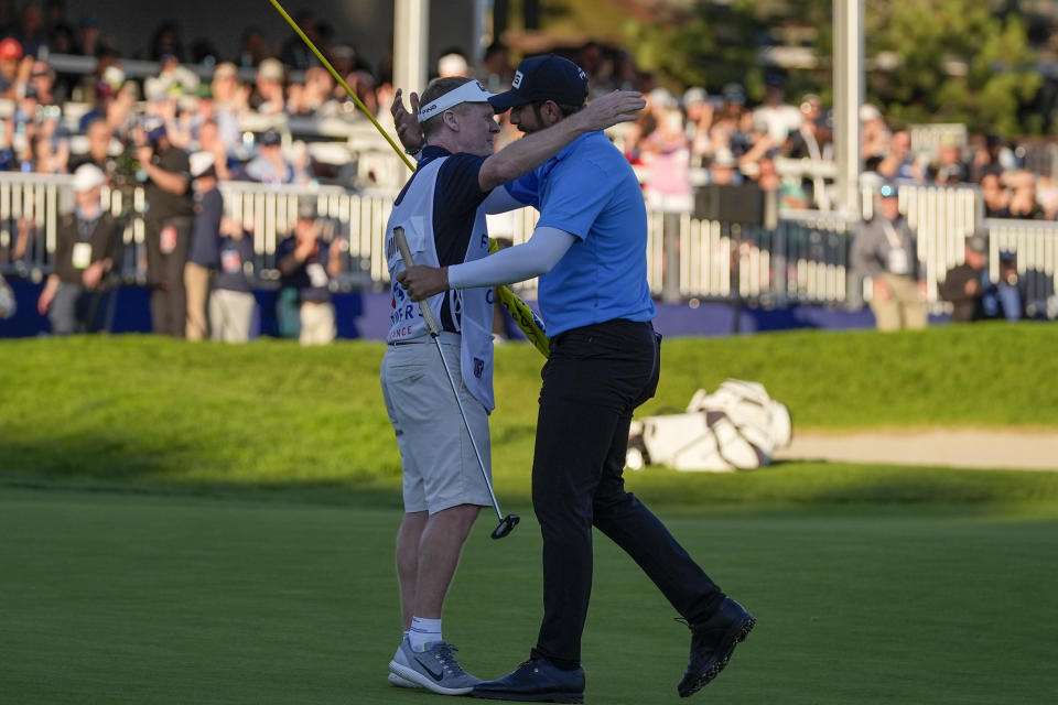 Matthieu Pavon, right, celebrates with caddy Mark Sherwood on the 18th green of the South Course at Torrey Pines after winning the Farmers Insurance Open golf tournament, Saturday, Jan. 27, 2024, in San Diego. (AP Photo/Gregory Bull)